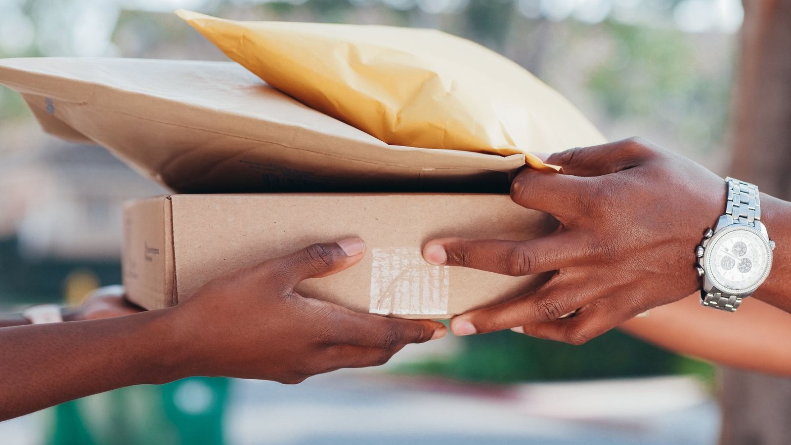 Courrier remettant un colis ecommerce et des enveloppes à un client