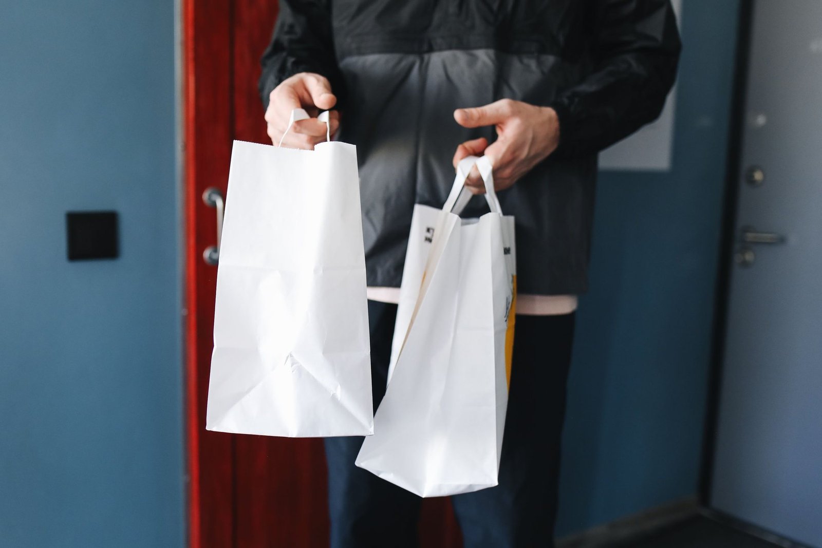 Shopper carrying loaded paper bags during a practical handle-use scenario