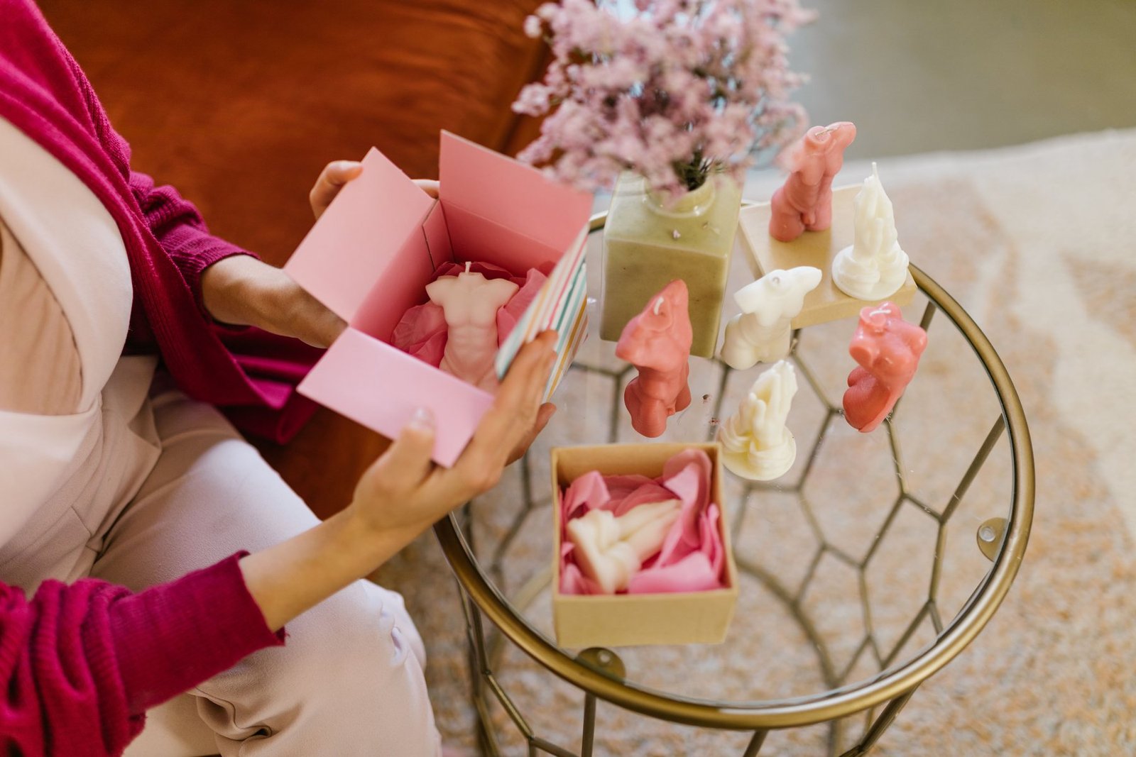 Femme emballage bougies décoratives dans une boîte à bougies personnalisée rose