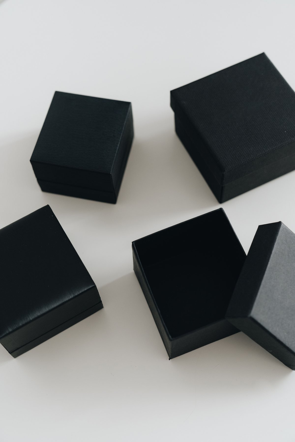 Minimalistische schwarze Schmuckkästen vertikal angeordnet zur Präsentation