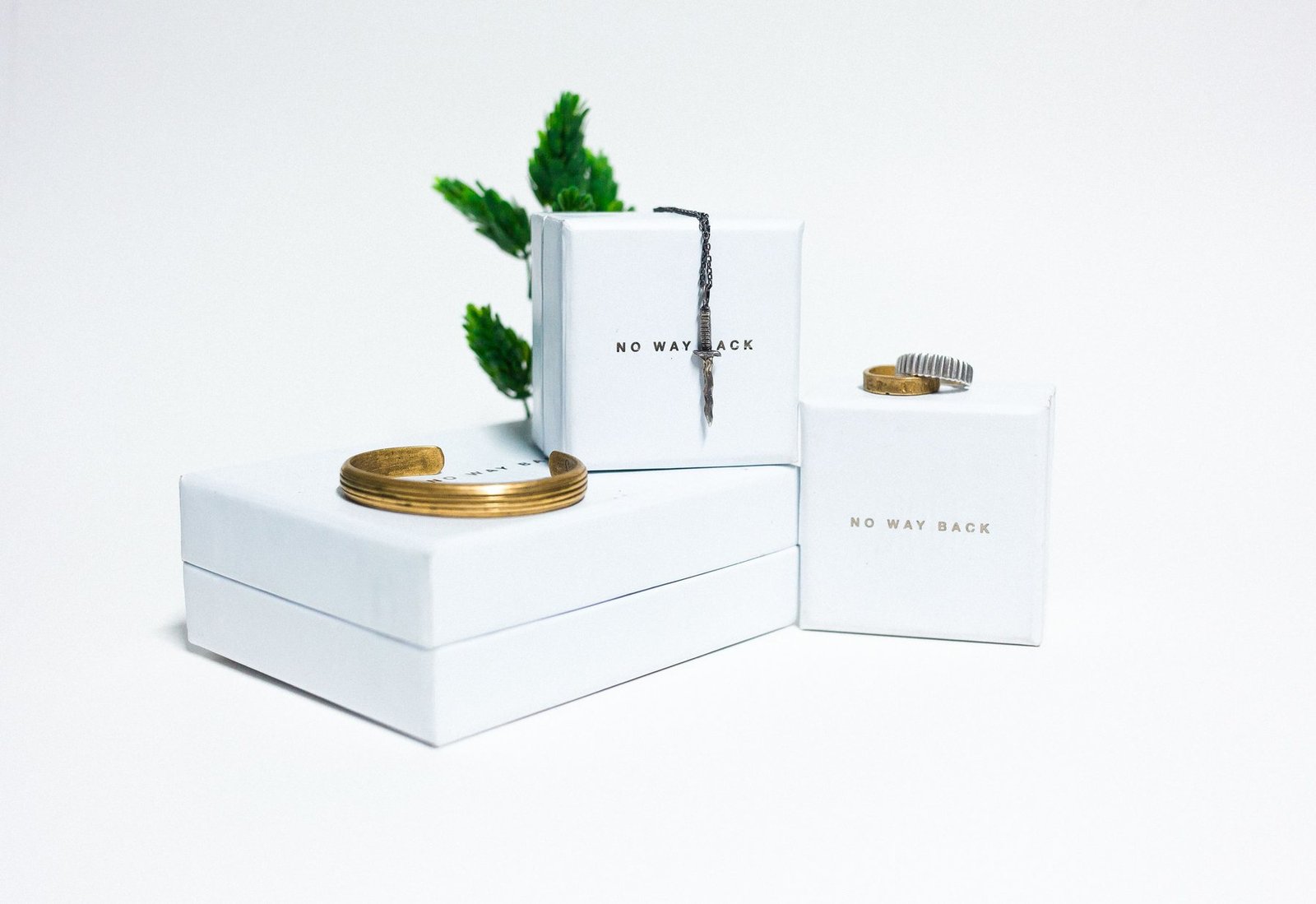 Minimalistischer Schmuck, der auf sauberen weißen Präsentationsboxen angeordnet ist
