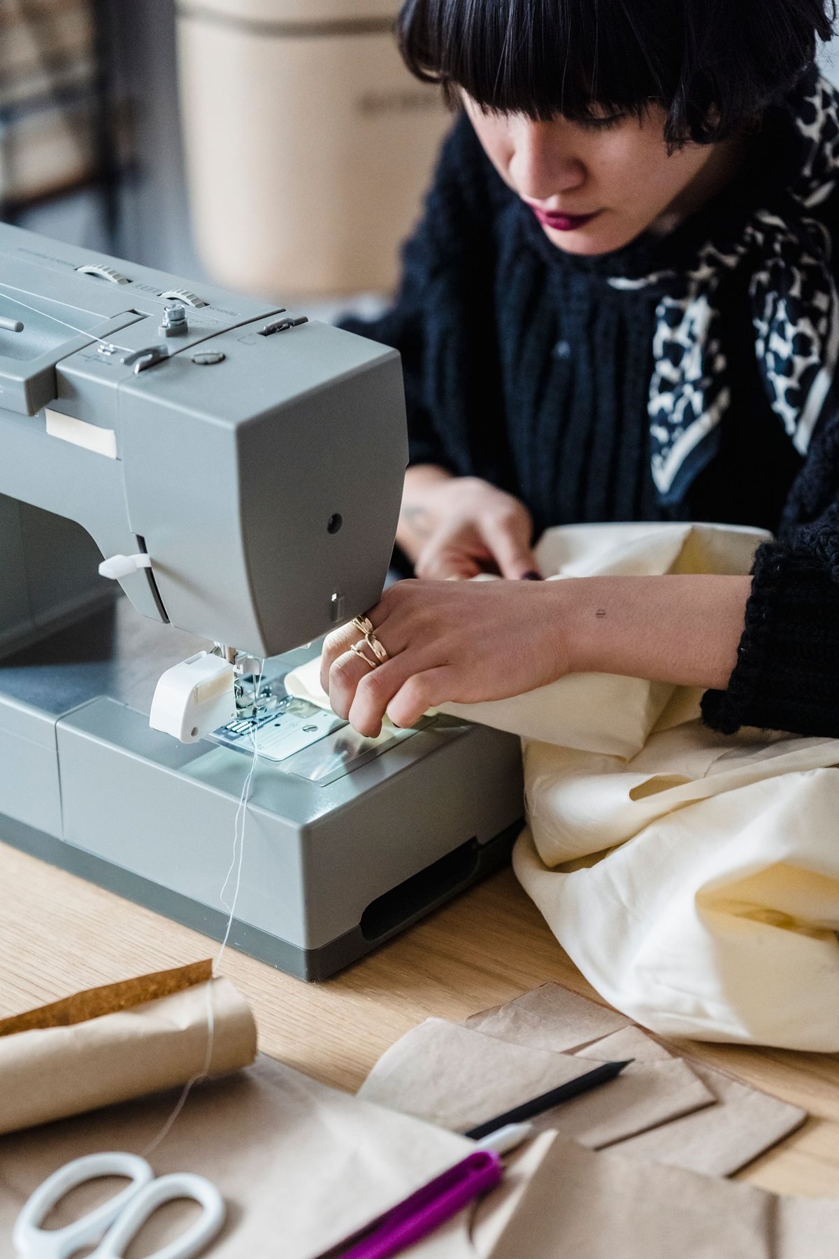 Näherin Nähen eines Kleidungsstücks an einer Maschine in einem Arbeitsatelier