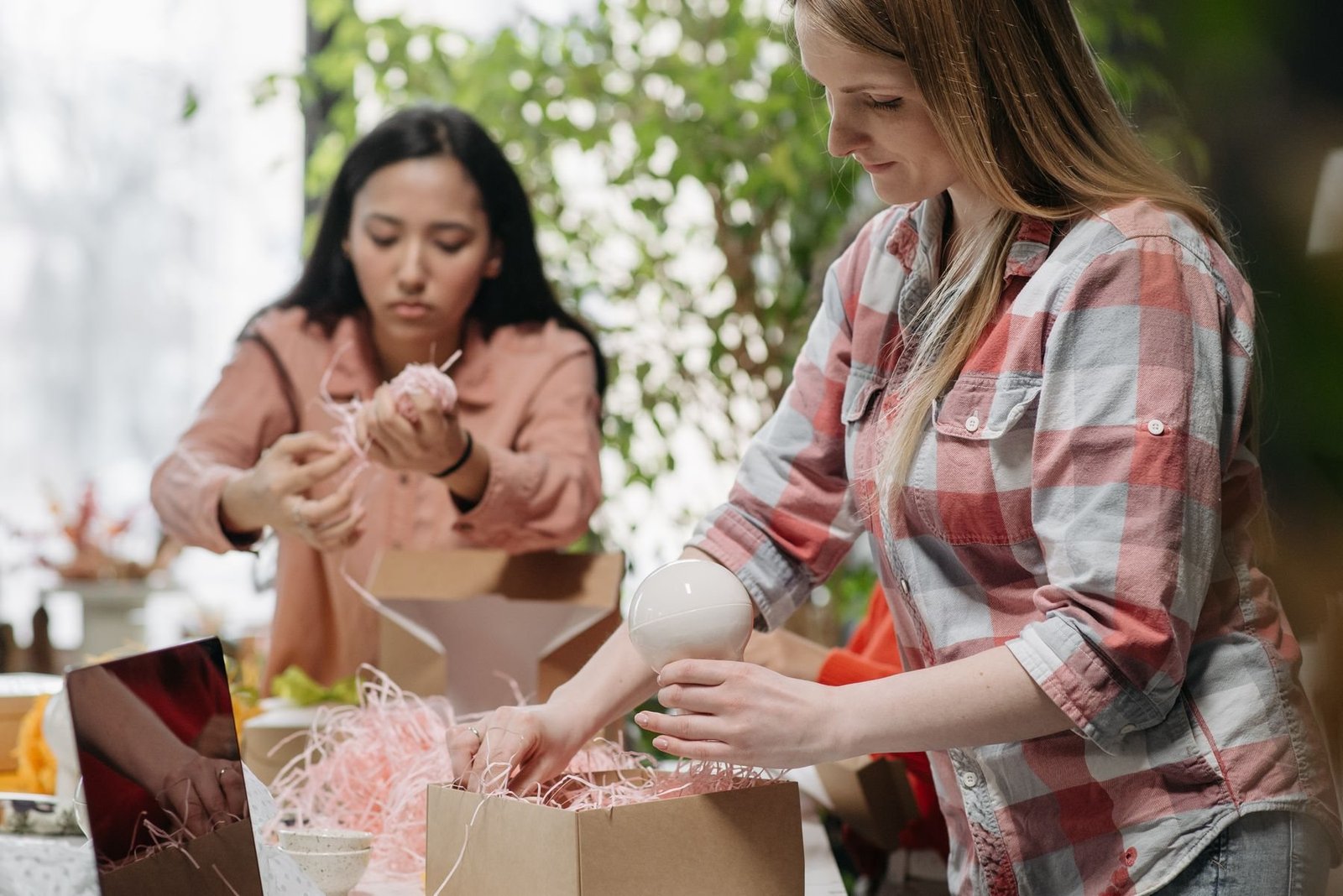 E-Commerce-Arbeiter, die echte Bestellungen in Wellpappe-Versandboxen verpacken