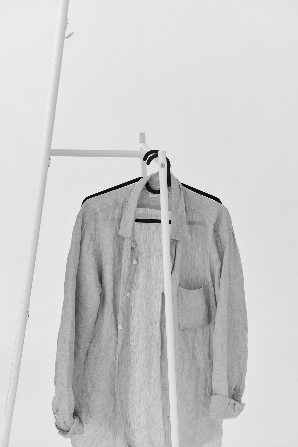 Linnen shirt opknoping aan een minimalistische kleding rail klaar voor bescherming