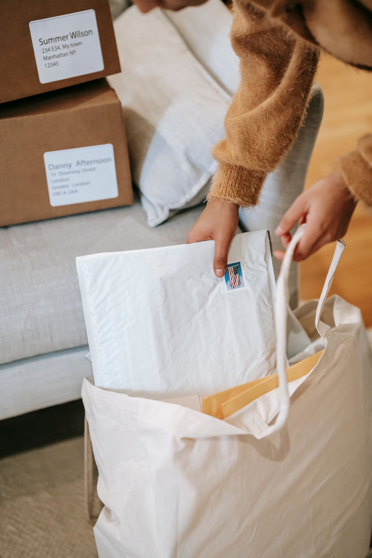 Personen die gewatteerde enveloppen en pakketten sorteren in een bezorgzak