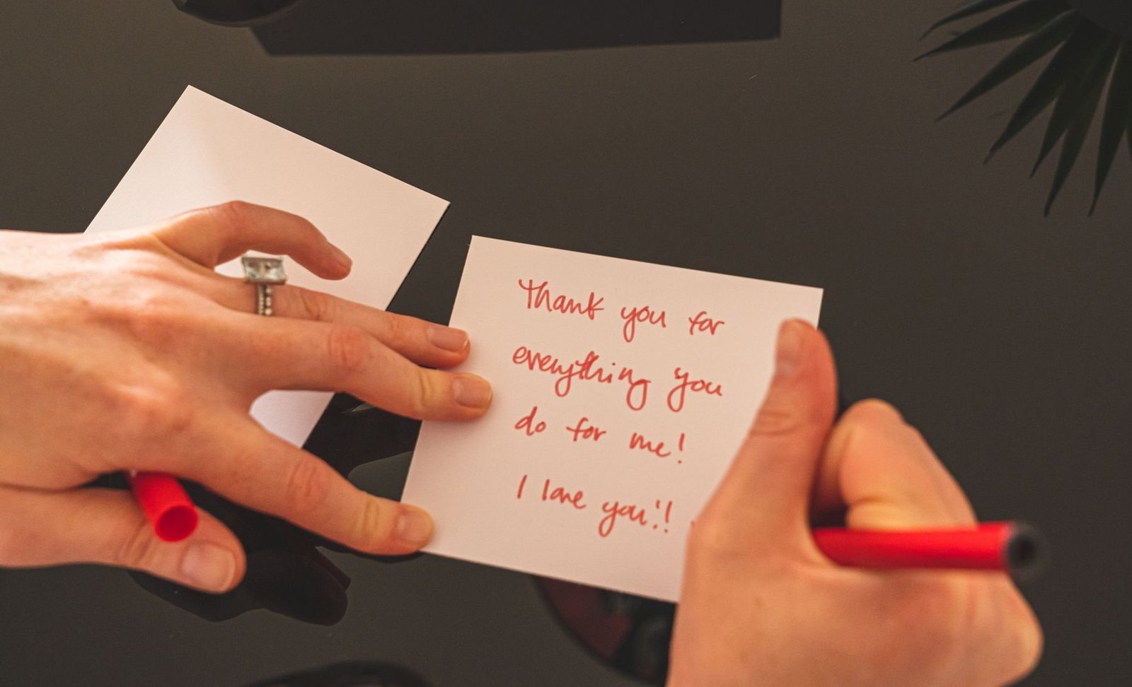 Persoon die een bedankbericht met de hand schrijft met een rode pen