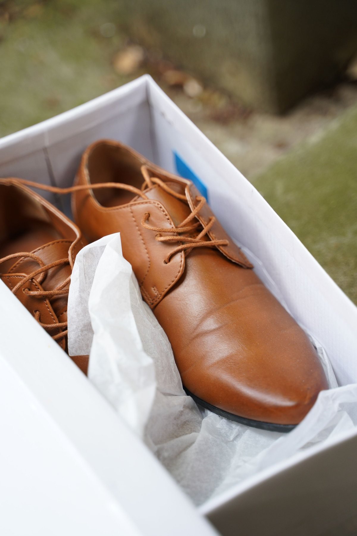 Lederschuhe in einem weißen Schuhkarton mit Umschlagpapier verpackt