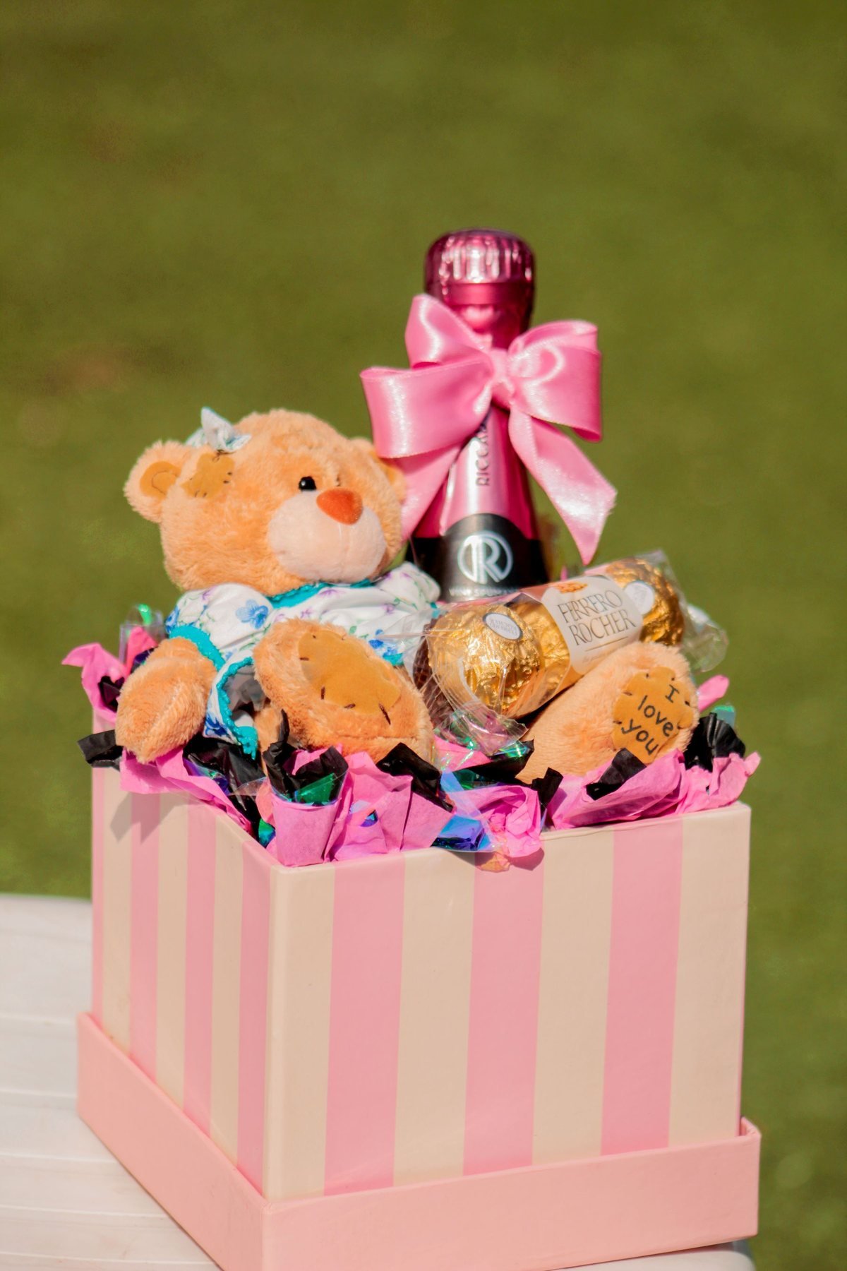 Ein Weingeschenkkorb mit Schokolade und einem Teddybären, der ein Mischproduktsortiment zeigt