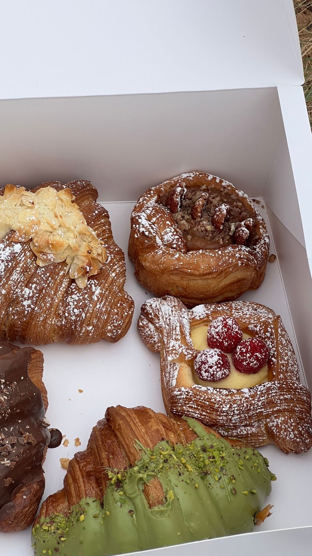 Croissants and pastries arranged in an open takeaway box for a loaded sample review