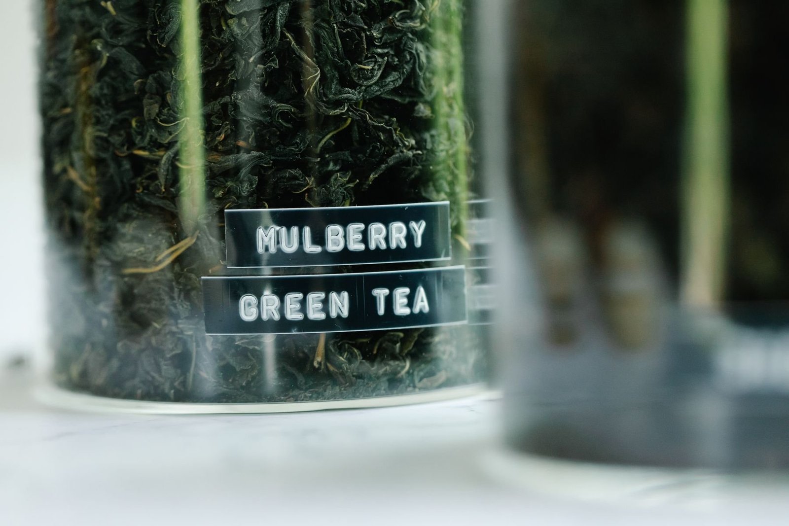 Dried tea leaves visible inside a labeled glass jar
