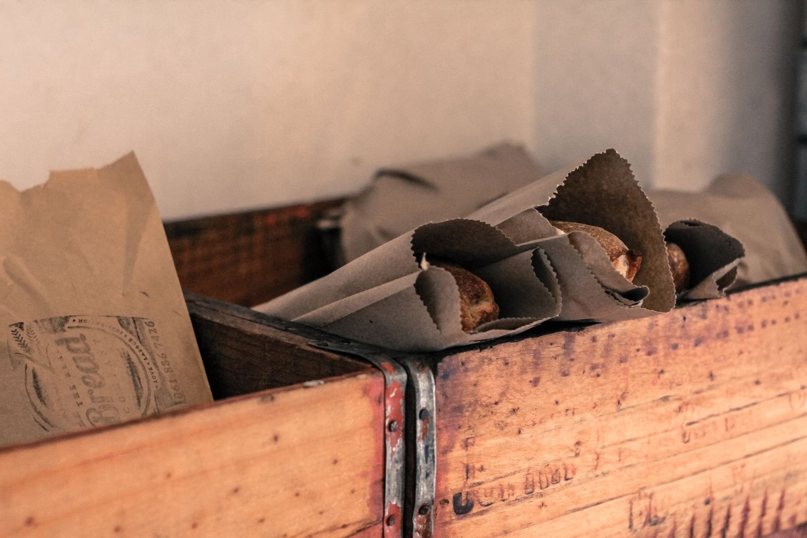 Brown paper bags and wrapping arranged in wooden bakery crates