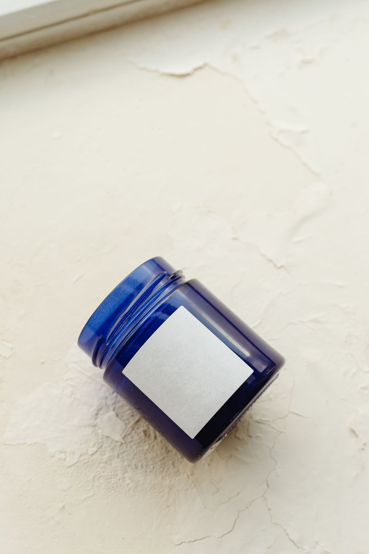 A blue glass jar showing the size and placement of a blank white label
