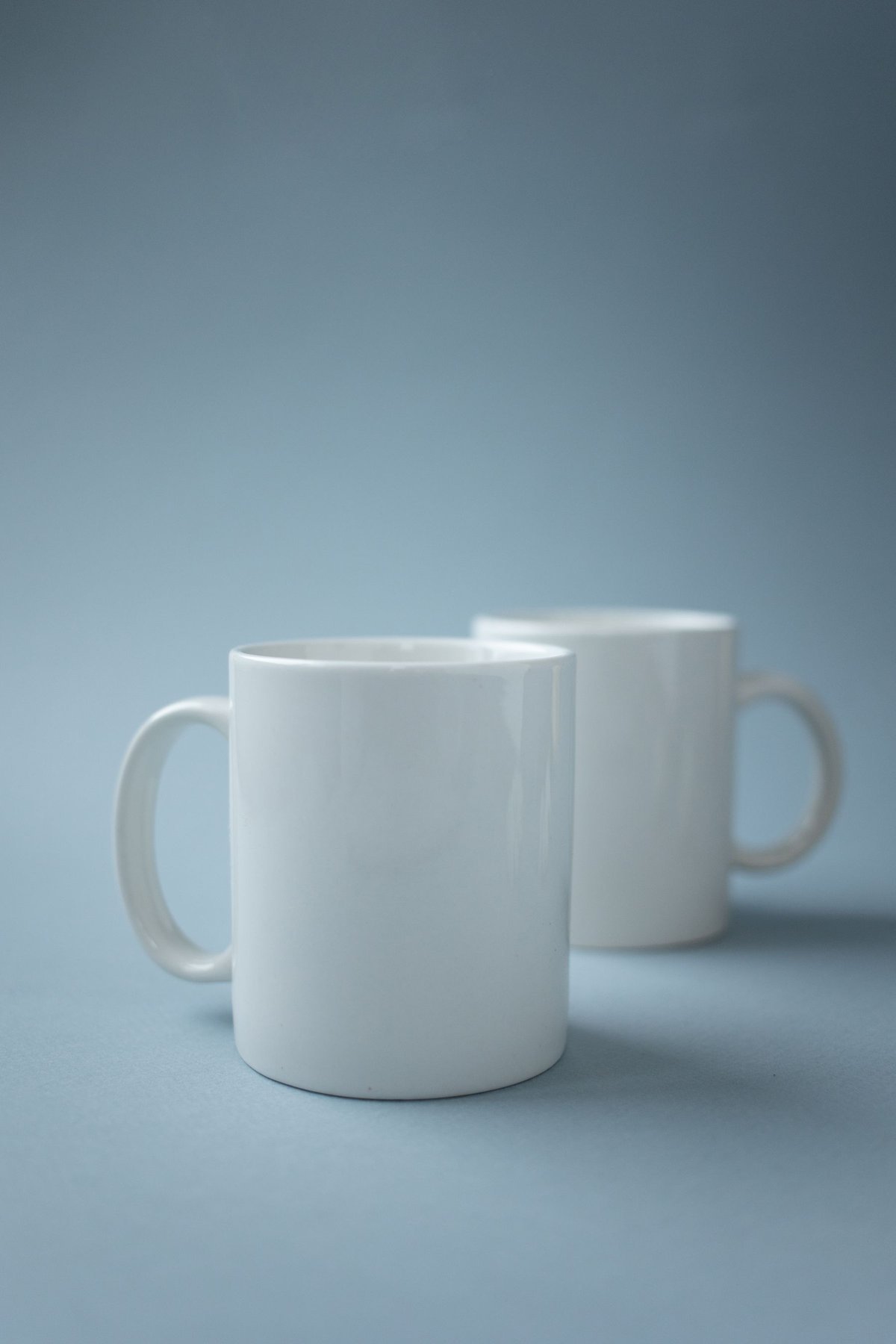 Two white ceramic mugs showing the handles that must be included in box measurements