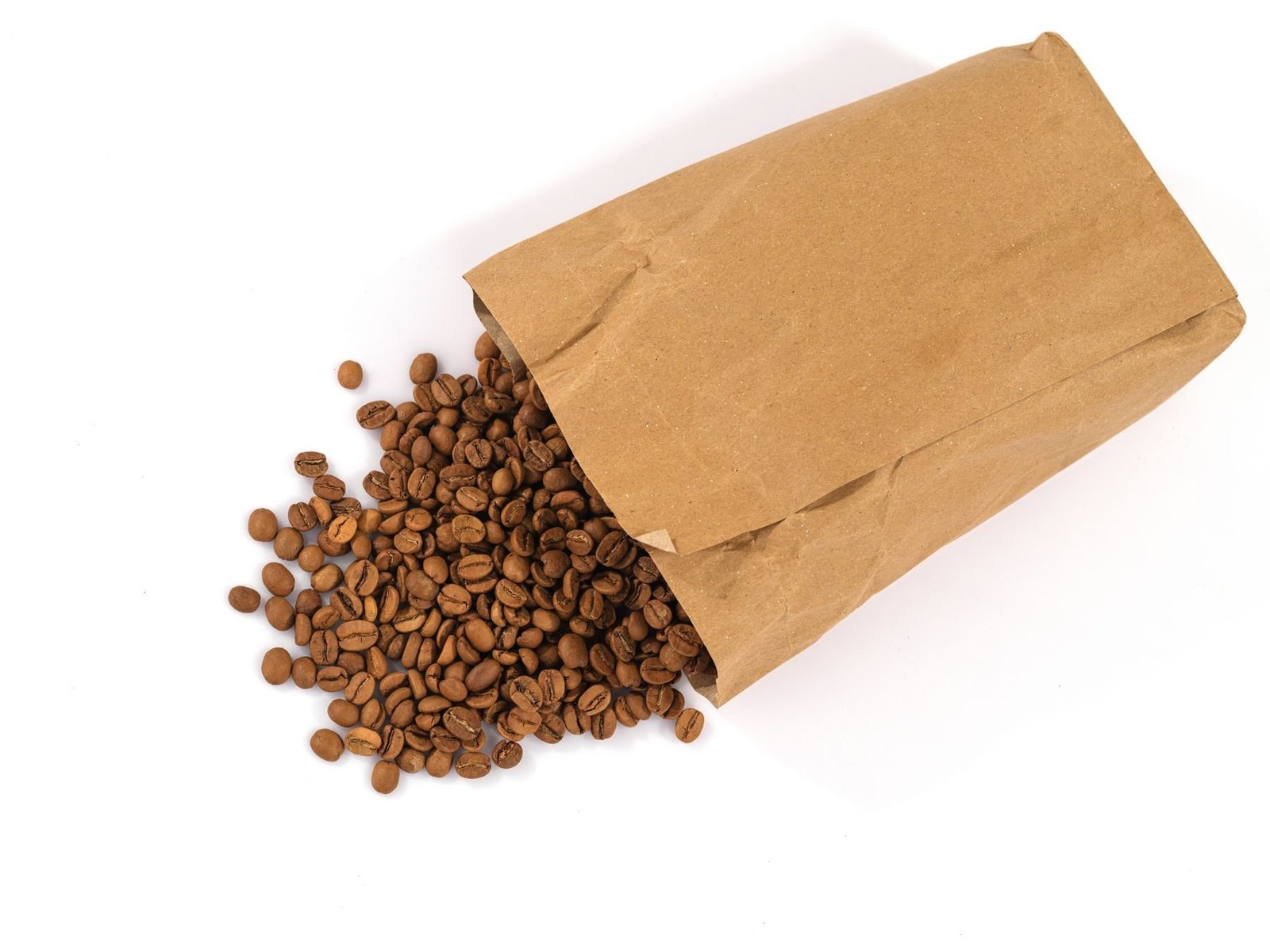 Roasted coffee beans spilling from a brown paper bag