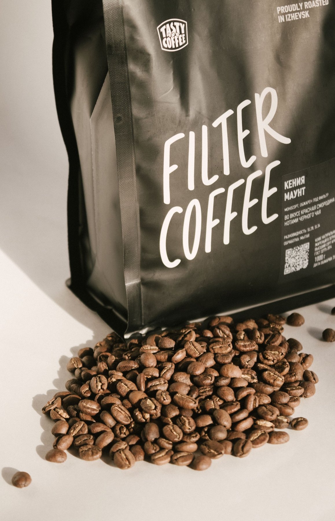 Black printed coffee packaging and scattered roasted beans