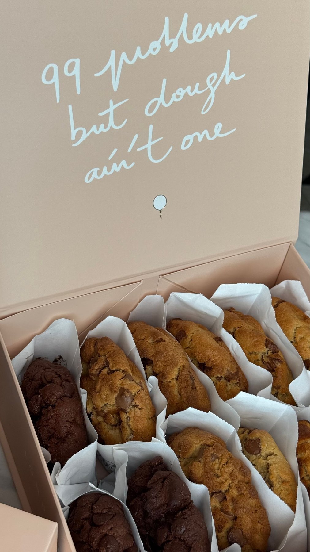 Cookies in paper sleeves inside an open printed presentation box