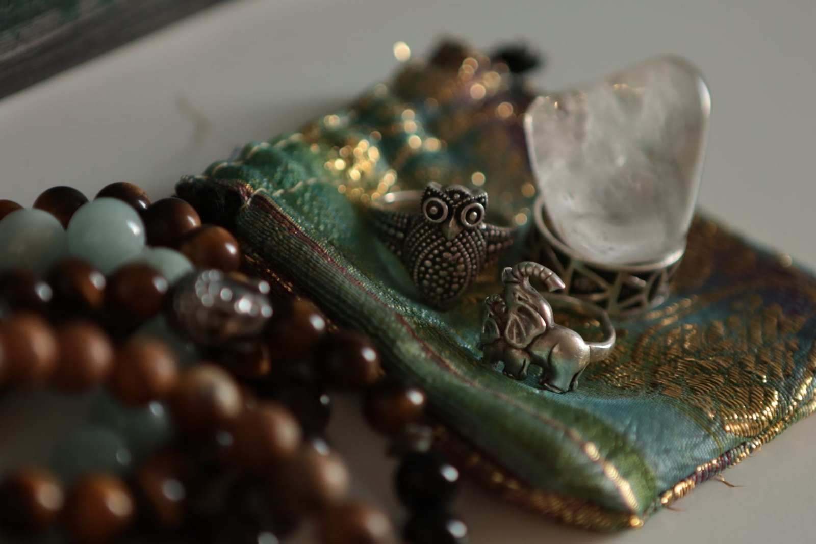 An assortment of beaded and metal jewelry on decorative fabric