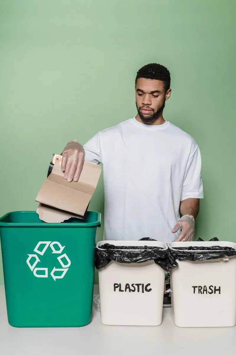 A person separating cardboard into a recycling container
