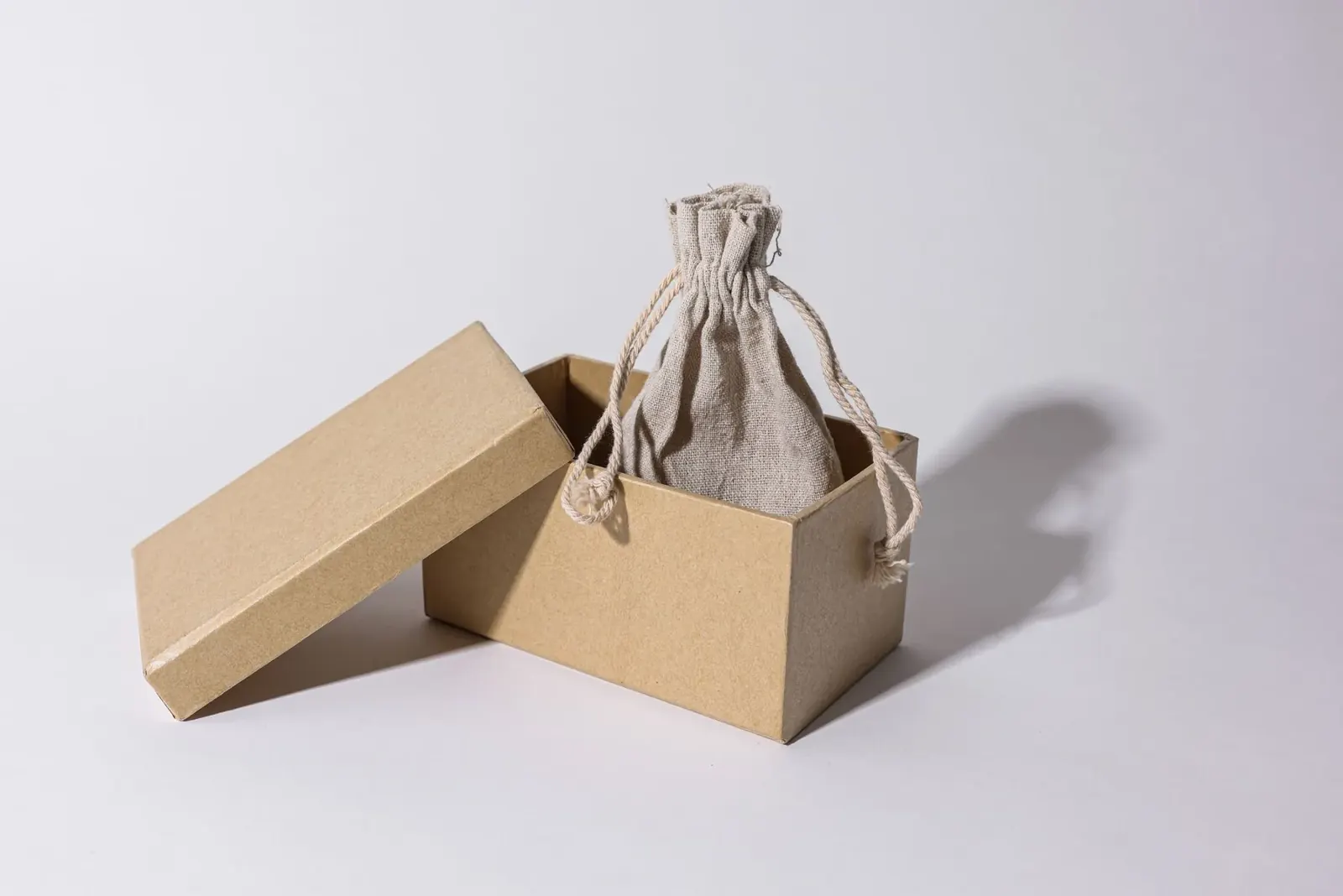 Natural textile pouch presented inside an open cardboard box