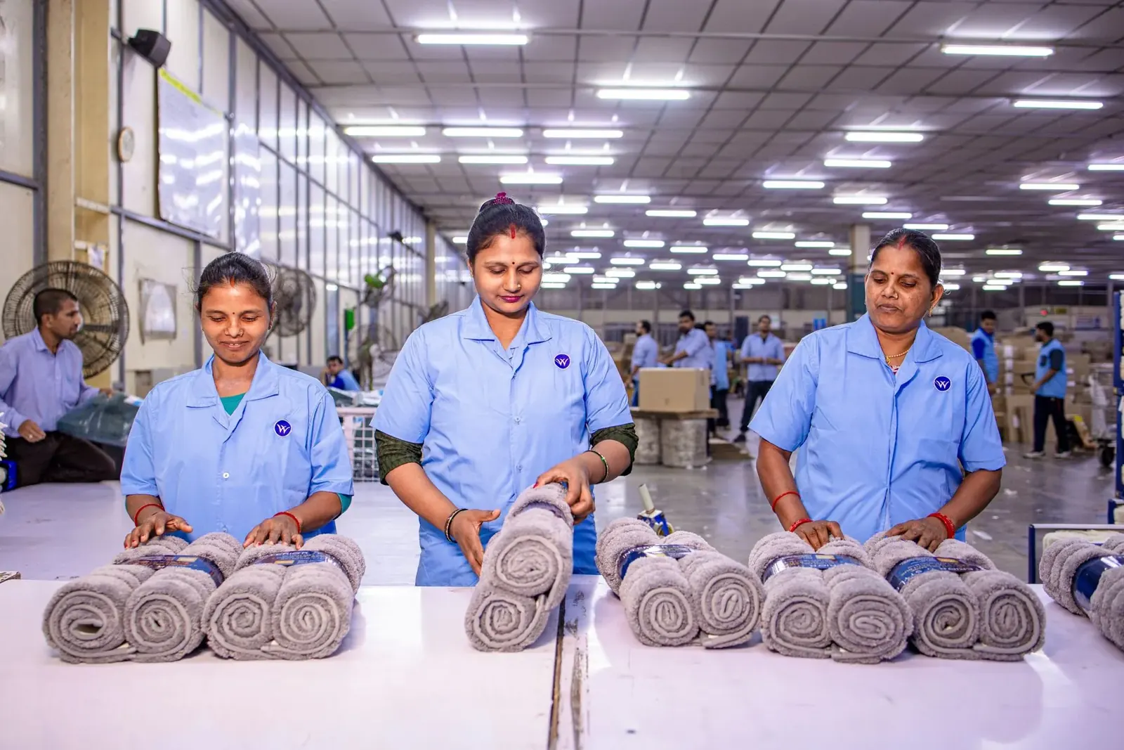 Textile factory team inspecting rolled goods during quality control