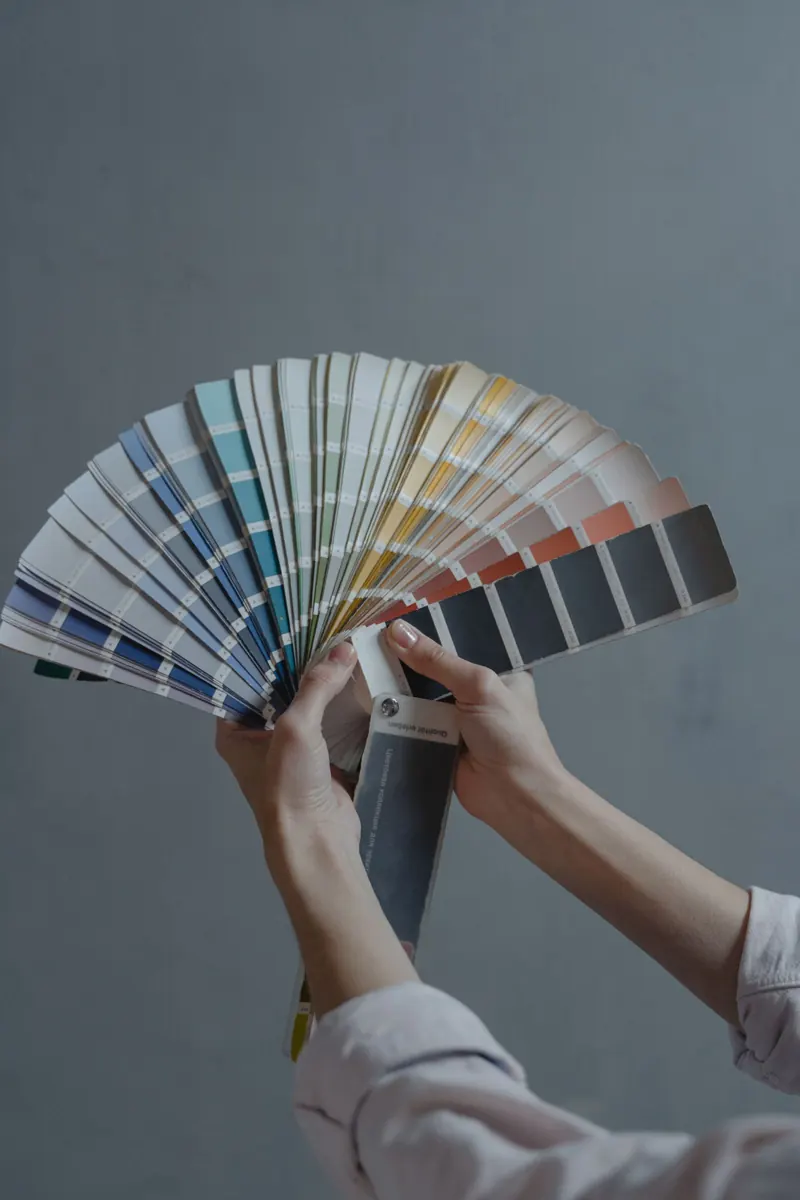 Hands comparing a fan of color swatches